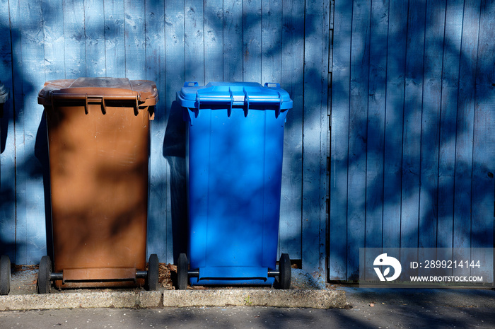 Wheelie bin colour blue, purple and black for refuge collection outside house in a row