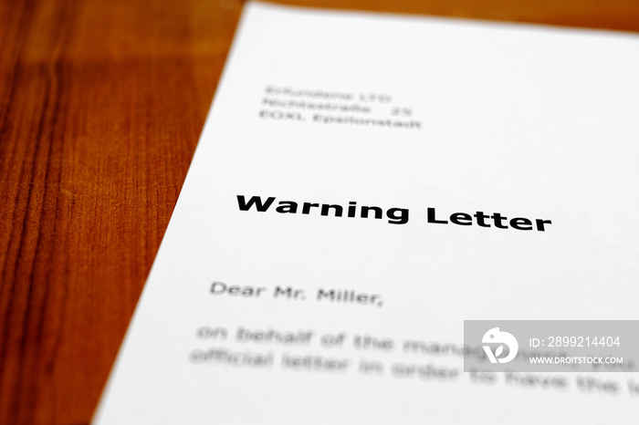 A letter on a wooden table - warning