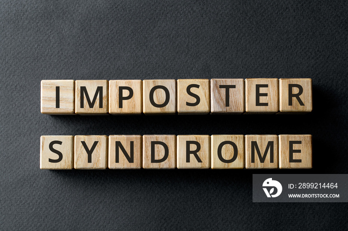 Impostor syndrome - phrase from wooden blocks with letters, psychological pattern inadequate incompetent Impostor syndrome concept, gray background