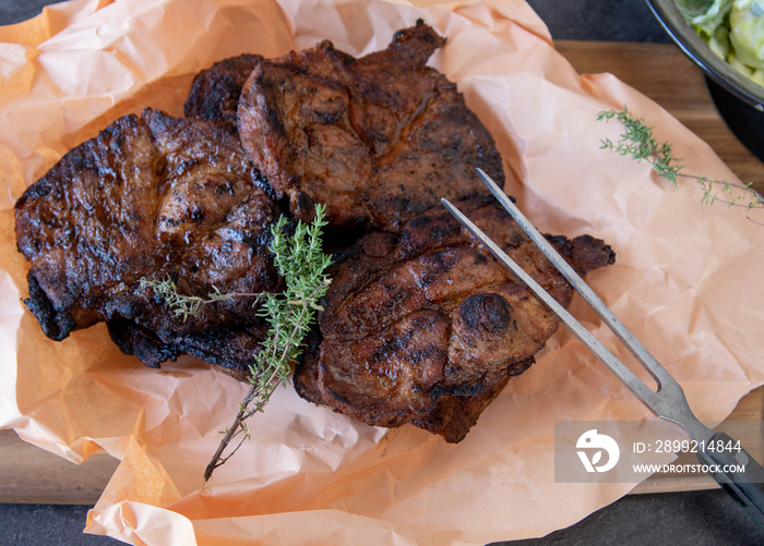 Fresh grilled pork steaks on butcher paper