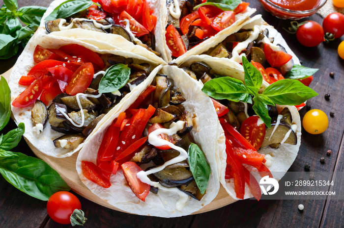 Tacos is a traditional Mexican snack. Eggplants, sweet peppers, tomatoes in pita bread. Vegetarian dish.