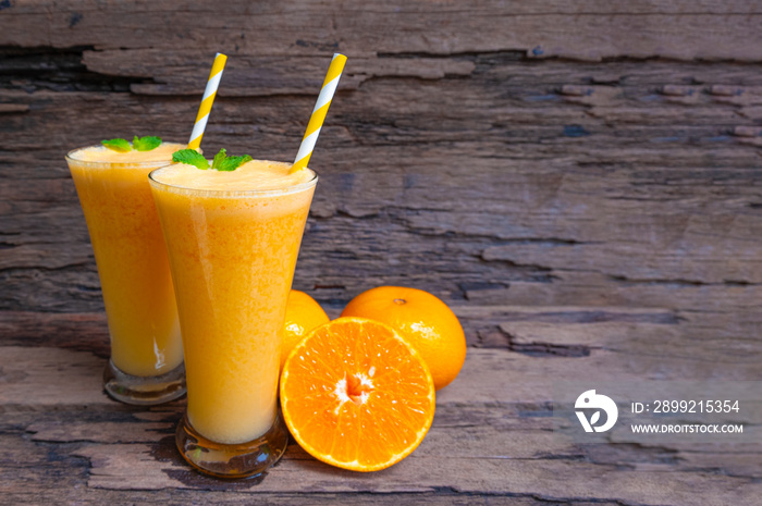 Orange juice fruit smoothies yogurt drink yellow healthy delicious taste in a glass slush for weight loss on wooden background.