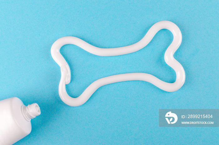 a bone from white toothpaste, animal teeth care concept, on blue background