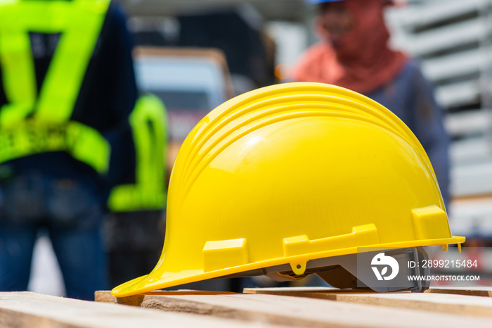 Yellow helmet in construction site and construction site worker background safety first concept