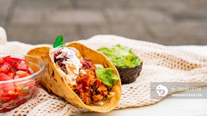 Mexican traditional authentic homemade tacos with pulled pork beef chili con carne serve with tomato salad and avocado guacamole and dip sauce