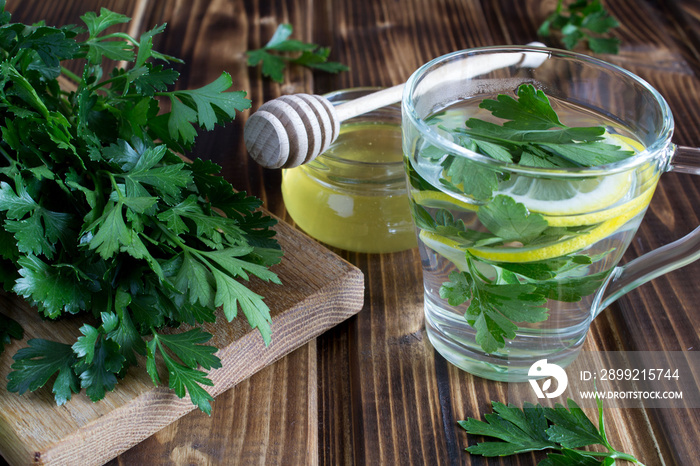 Tea with parsley,honey and lemon on the wooden background