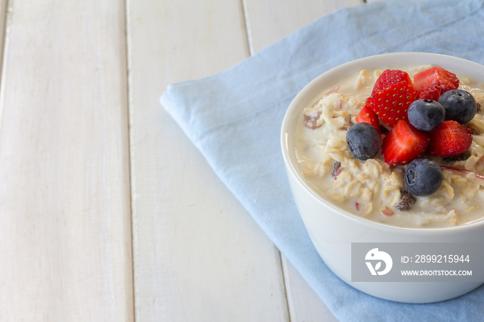 Bircher Muesli with Fresh Strawberries and Blueberries on Top with Copy Space Horizontal