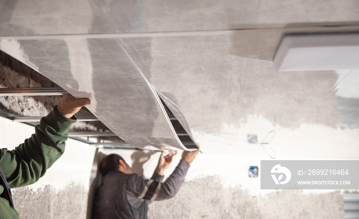 Construction worker assemble a suspended ceiling.