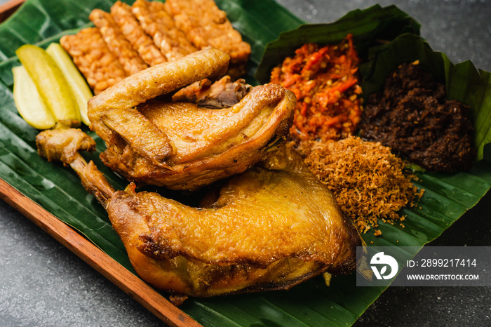 ayam goreng bumbu kuning, fried chicken with madura spicy sambal, tempeh and cucumber pickle