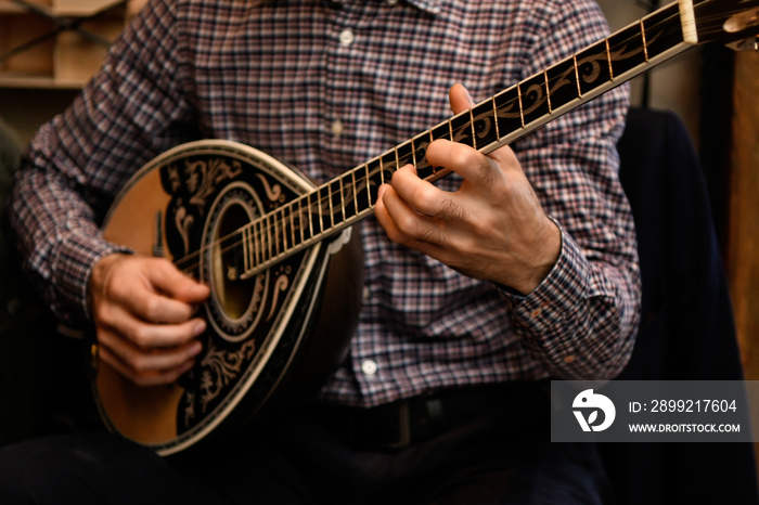 Playing the greek bouzouki at a restaurant.