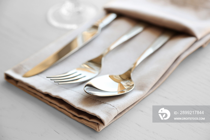 Fork, spoon and knife on linen napkin