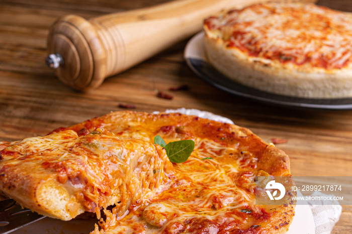 Chicago Style Deep Dish Cheese Pizza with Tomato Sauce, on wooden background