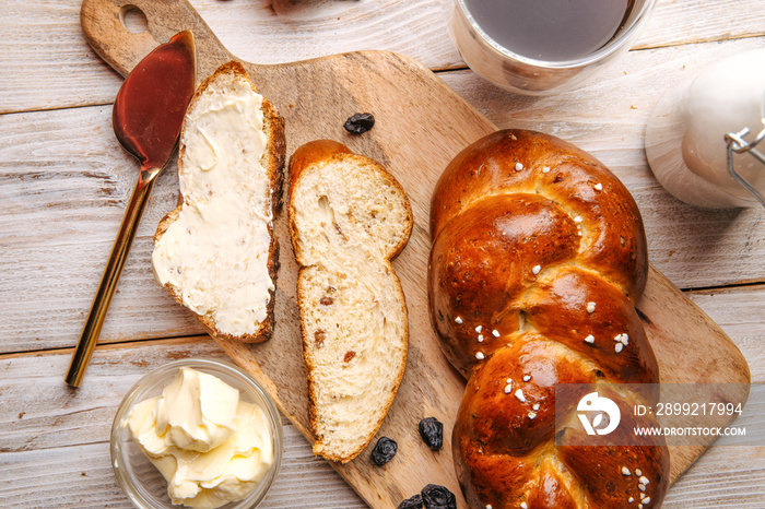 Top view on sweet raisins bun pigtail bread on the decorated wooden background