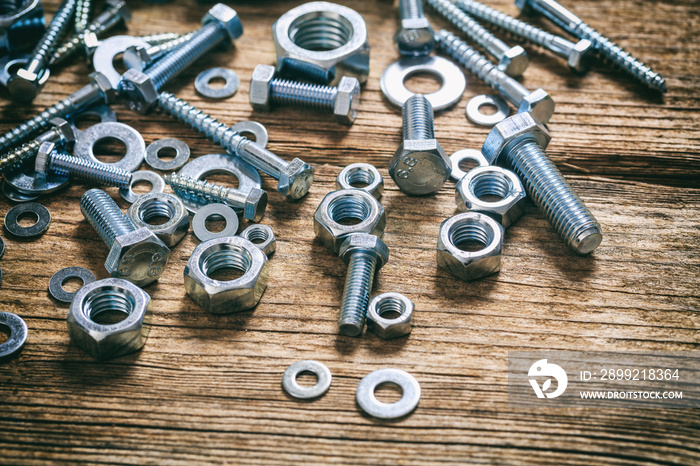 Bolts and nuts on wooden background