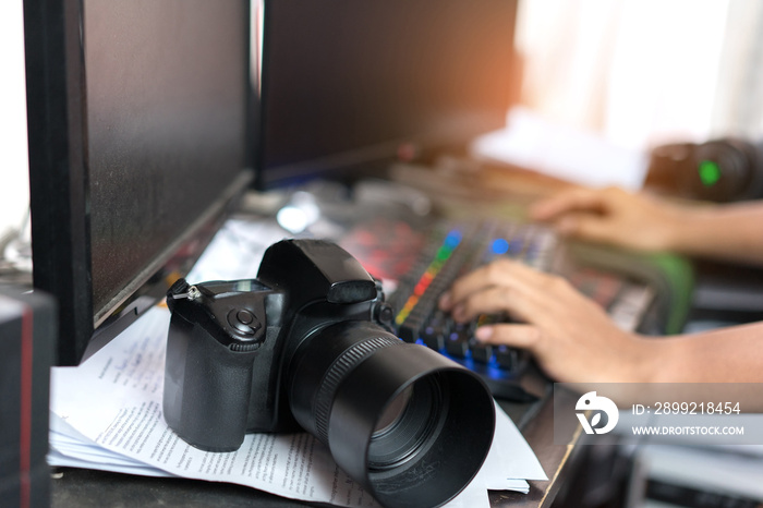 Photographer editing and retouch photos with camera, double screen at home