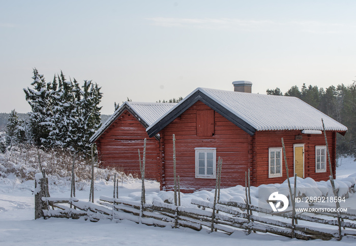 Farm barn and house in a cold winter landscape with snow and frost