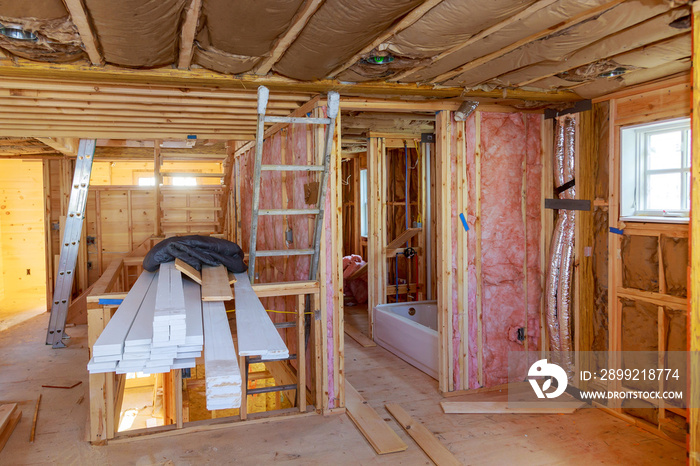 Mineral glass wool in a wooden frame on a inclined wall near the wooden ceiling in a private house.