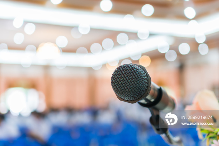 Seminar Conference Concept : Close-up Microphones on abstract blurred of speech in conference meeting room, front flowers speaking blur bokeh light in event convention hall in hotel background