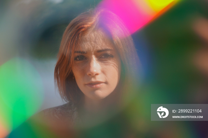 funky colorful portrait of a young woman with lens flare and light leaks - authentic real people creative portraiture