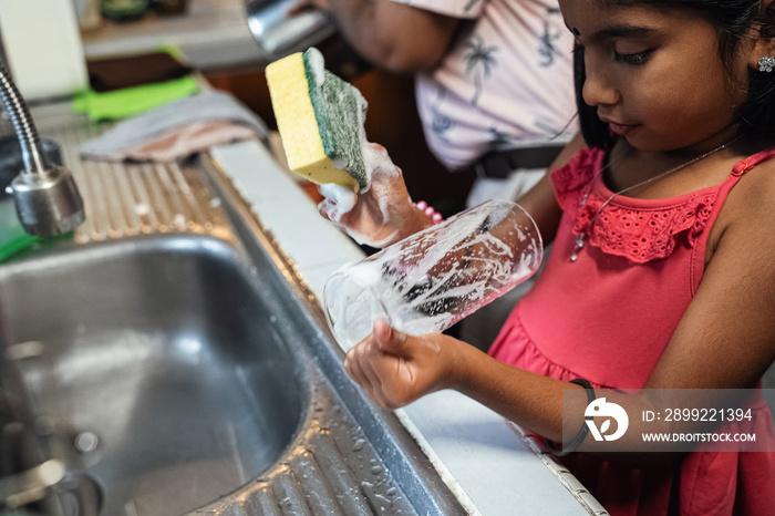 Children helping their parents wash up after dinner