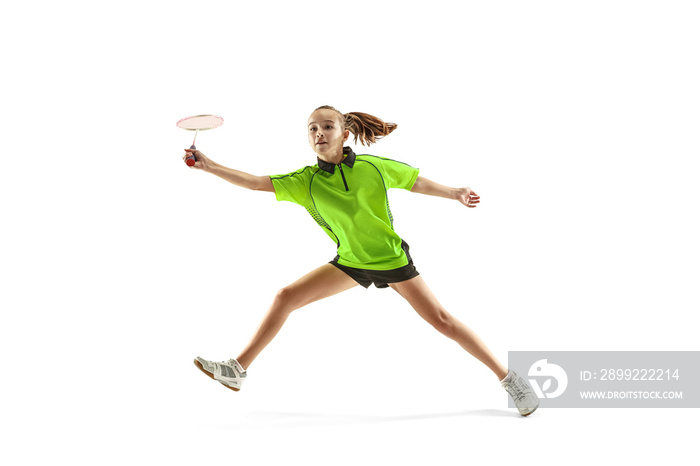 The one caucasian young teenager girl playing badminton at studio. The female teen player isolated on white background in motion