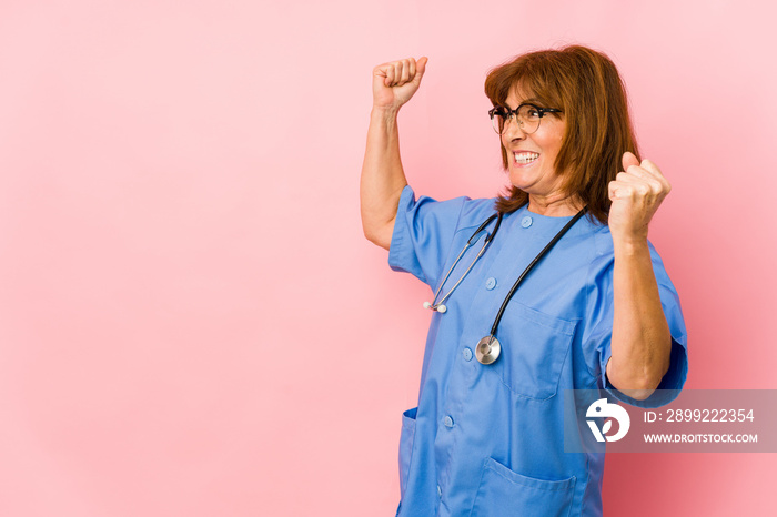 Middle age caucasian nurse woman isolated raising fist after a victory, winner concept.