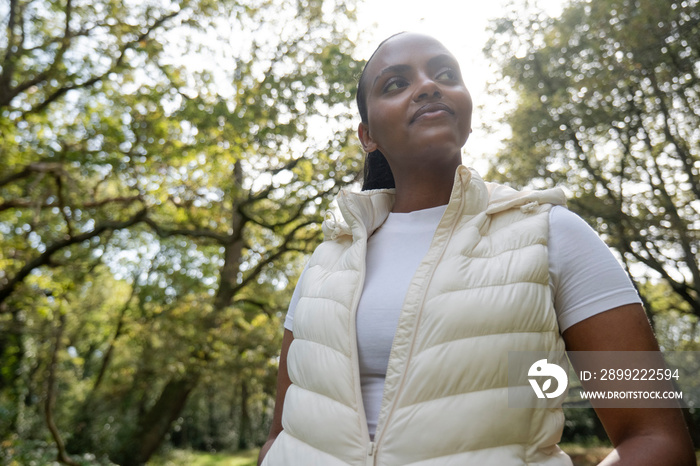 Portrait of young woman relaxing in park on sunny day