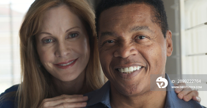 Close up portrait of senior couple smiling by window