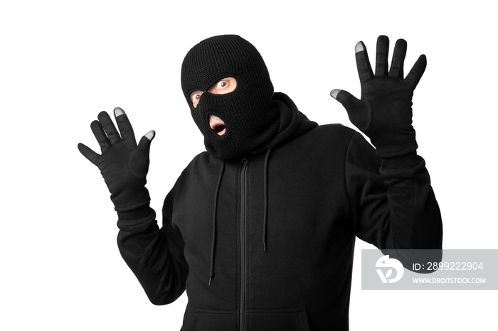 Arrested masked thief with raised arms isolated over white wall