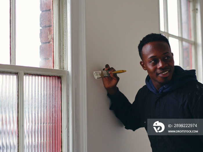 Man painting house walls white