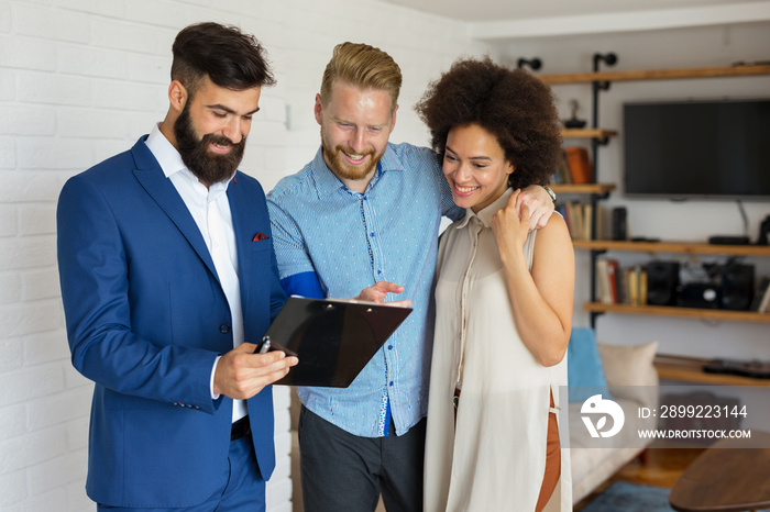 Young couple consulting with financial adviser at home.