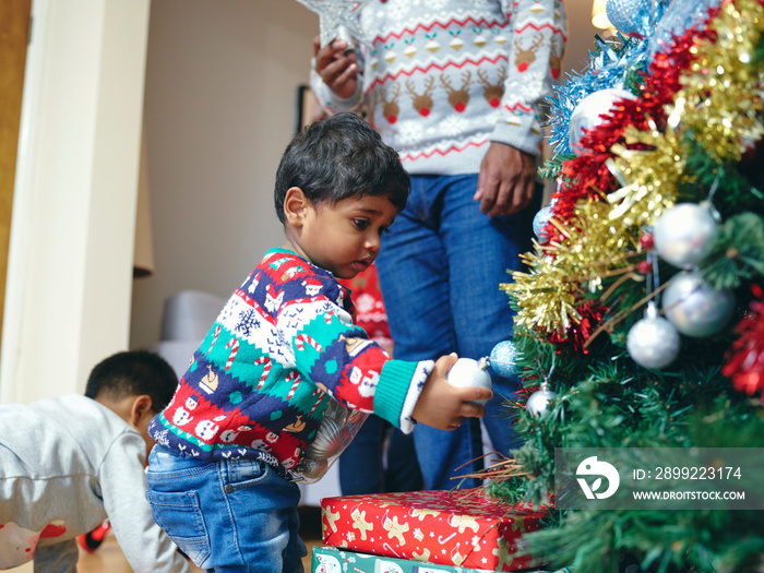 Father and sons decorating Christmas tree