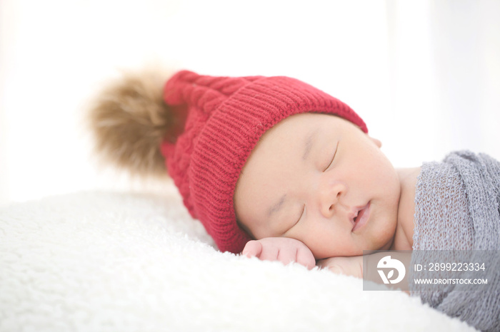 Lovely newborn Asian baby sleeping on furry cloth