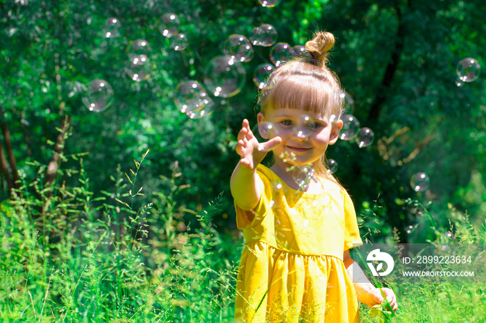 Little girl blows soap bubbles