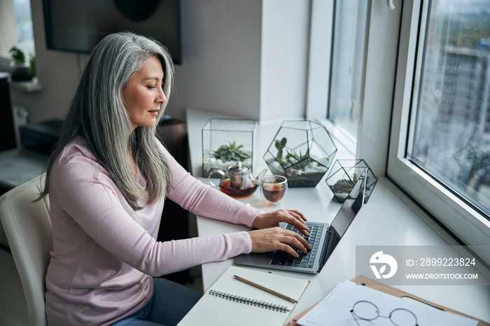 Charming woman working on notebook at home