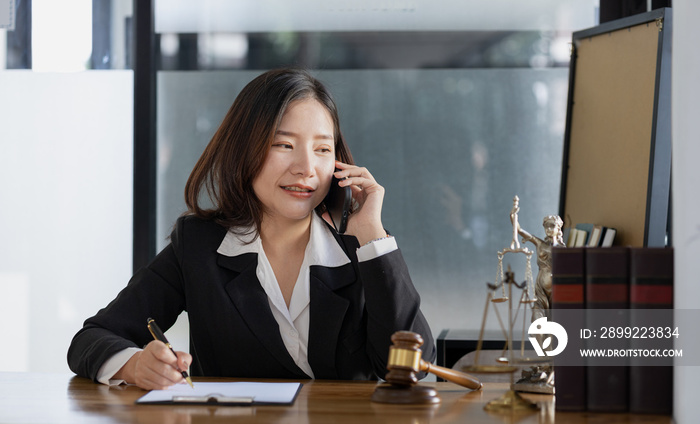 A woman on the phone, she is a lawyer to defend the case, she gives advice on the phone to a client who calls to discuss a company employee embezzlement lawsuit. Lawyer concept and justice.