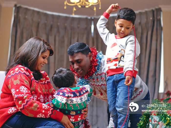 Parents and sons playing with Christmas decorations