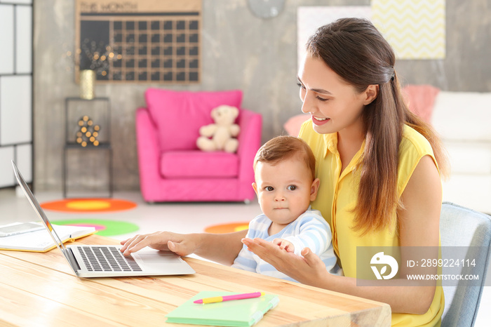 Young woman with baby working in home office