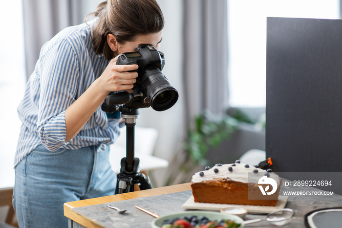 blogging, profession and people concept - female food photographer with camera photographing cake in kitchen at home