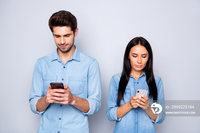 Portrait of his he her she nice attractive charming lovely focused concentrated couple holding in hands cell using 5g app connection fast speed isolated over light white gray pastel color background