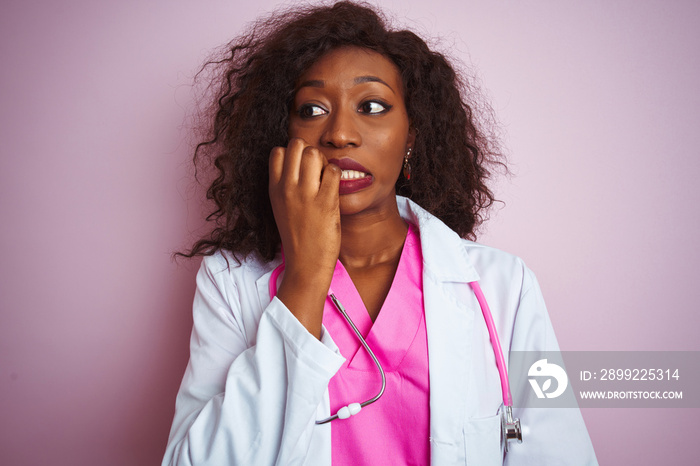 African american doctor woman wearing stethoscope over isolated pink background looking stressed and nervous with hands on mouth biting nails. Anxiety problem.