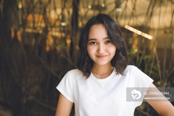 Cheerful optimistic asian girl in a white t-shirt, smiling