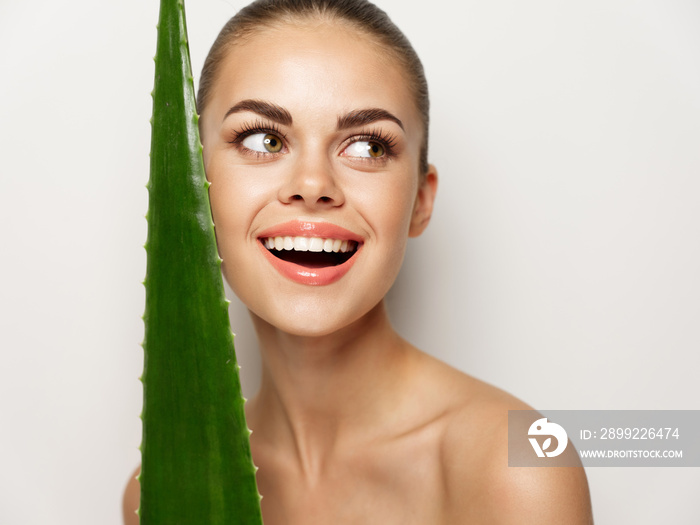 happy woman smiling and holding green aloe leaf in hand fun emotion model