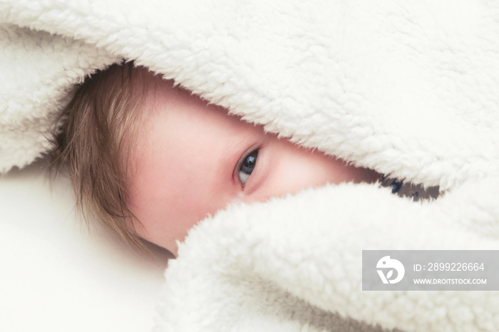 Baby peeking under the blanket