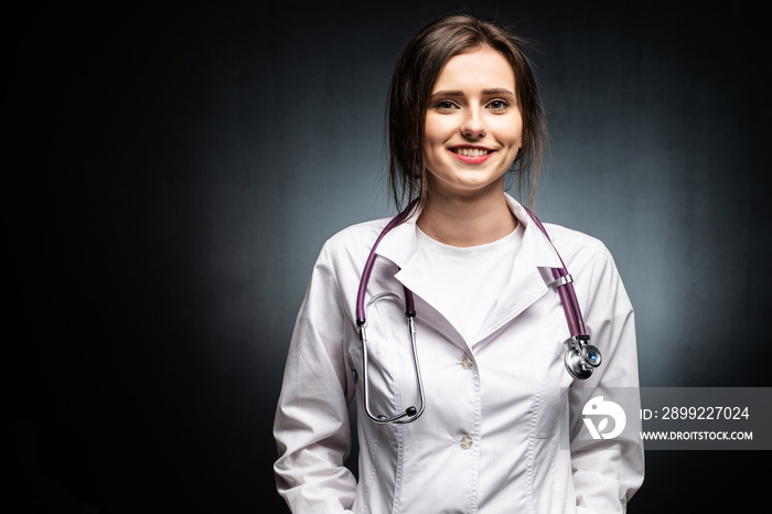 Portrait of serious doctor woman on black background