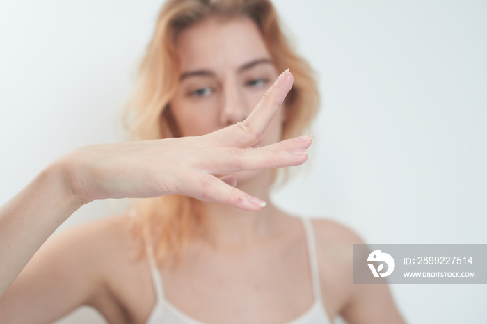 Hypermobility of the joints. The girl flexes the fingers on white background