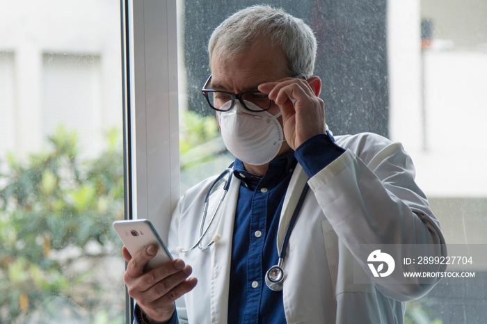 doctor with mask using mobile phone