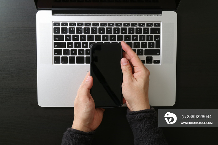 cyber security internet and networking concept.Businessman hand working mobile phone on laptop computer background