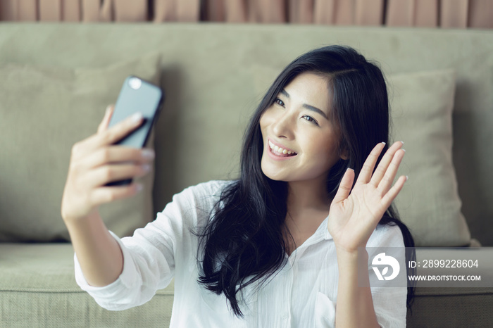 Selfie mania! Excited,Young attractive Asian woman making selfie on a smartphone camera or recording video vlog on a mobile phone. popular vlogger smiling to followers communicating by webcam online