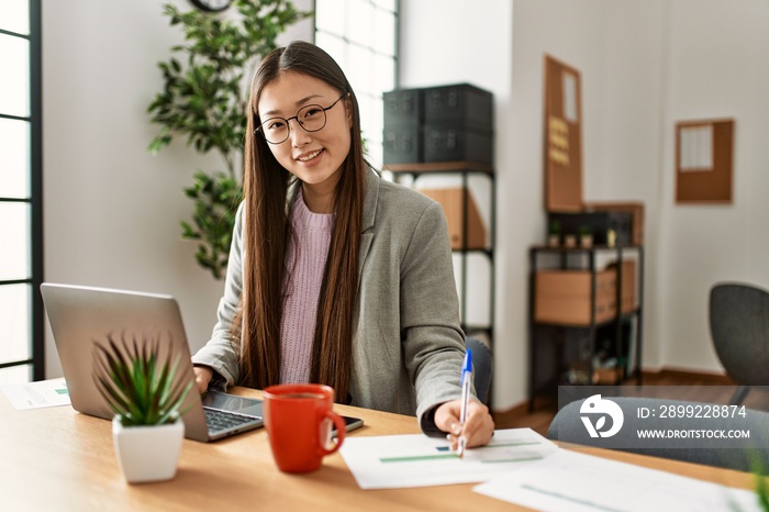 Young chinese businesswoman using laptop working at the office.